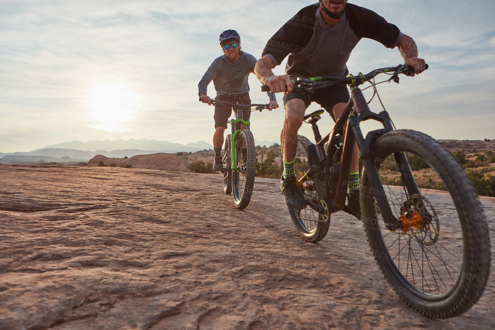 Buy stock photo Shot of two men out mountain biking together during the day