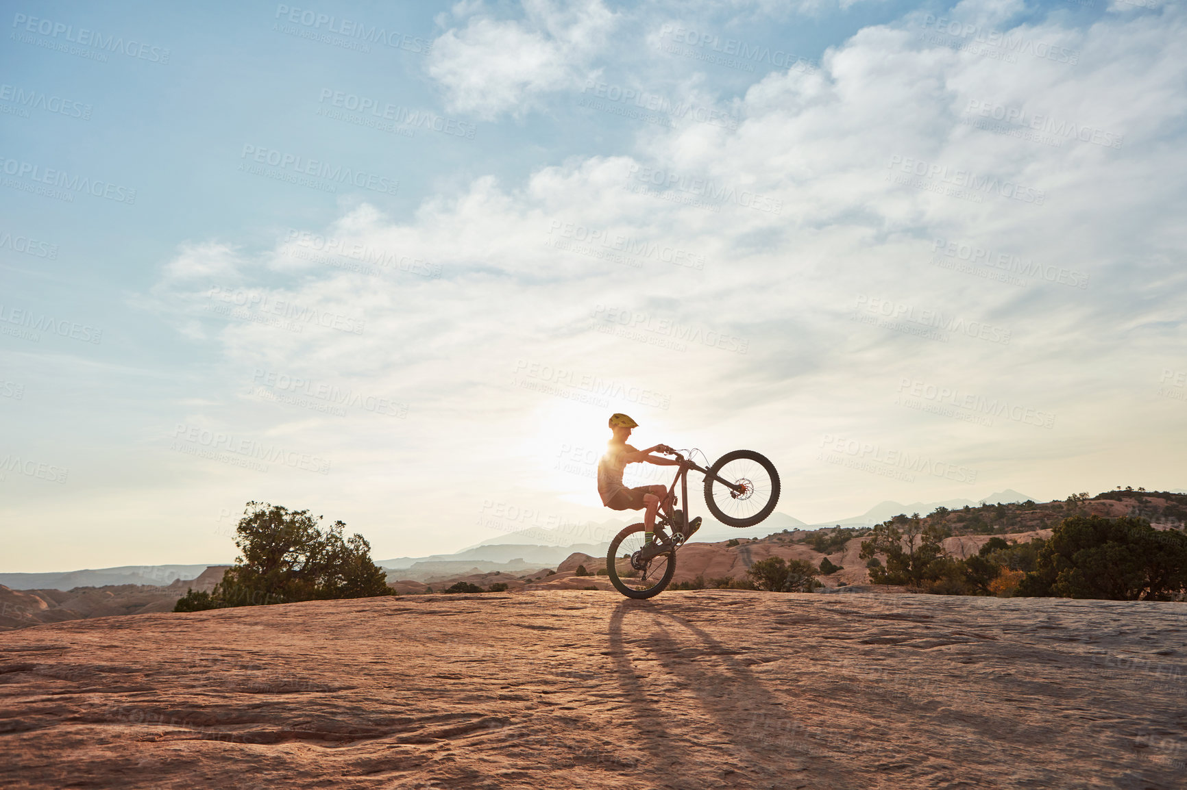 Buy stock photo Balance, man or extreme sport on mountain bike outdoor with action stunt, adventure or space. Sunshine flare, bicycle or person wheelie on rocky terrain for freestyle trick, adrenaline or performance