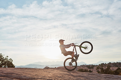 Buy stock photo Shot of a young man out mountain biking during the day