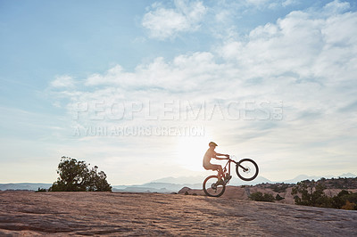 Buy stock photo Shot of a young man out mountain biking during the day