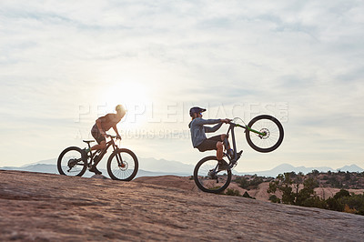 Buy stock photo Full length shot of two men out mountain biking together during the day