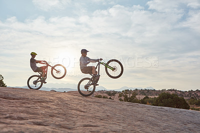 Buy stock photo Full length shot of two men out mountain biking together during the day