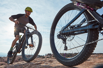 Buy stock photo Cropped shot of two athletic men mountain biking through the wilderness