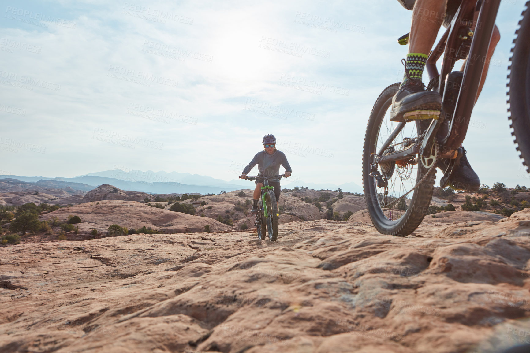 Buy stock photo Cropped shot of two athletic men mountain biking through the wilderness