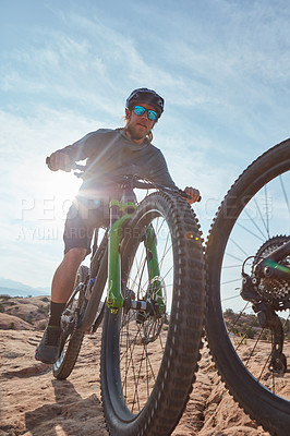 Buy stock photo Cropped shot of two athletic men mountain biking through the wilderness