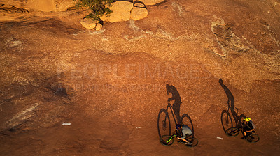 Buy stock photo High angle shot of two young male athletes mountain biking in the wilderness