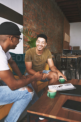 Buy stock photo Shot of two men laughing while sitting together in a coffee shop