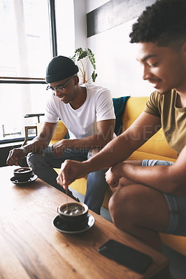 Buy stock photo Cropped shot of two men having coffee while sitting together in a cafe