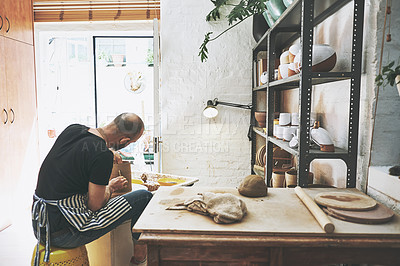 Buy stock photo Shot of an unrecognisable man working with clay in a pottery studio