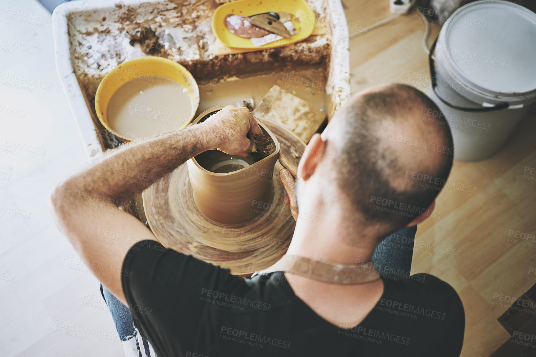 Buy stock photo Shot of an unrecognisable man working with clay in a pottery studio