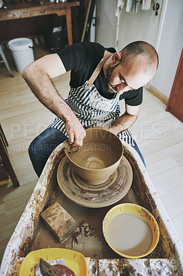 Buy stock photo Shot of a young man working with clay in a pottery studio