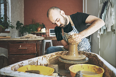 Buy stock photo Shot of a young man working with clay in a pottery studio