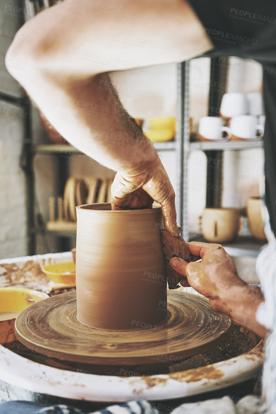 Buy stock photo Shot of an unrecognisable man working with clay in a pottery studio