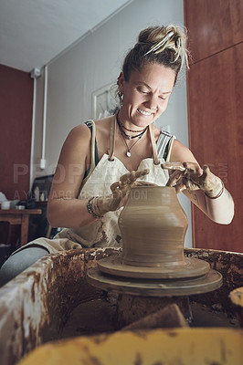 Buy stock photo Shot of a young woman working with clay in a pottery studio