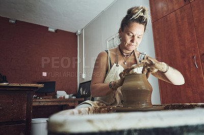 Buy stock photo Shot of a young woman working with clay in a pottery studio