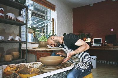 Buy stock photo Shot of a young man working with clay in a pottery studio