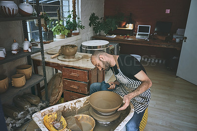 Buy stock photo Shot of a young man working with clay in a pottery studio