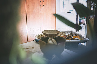 Buy stock photo Shot of a bowl made out of clay on a pottery wheel in a ceramic studio