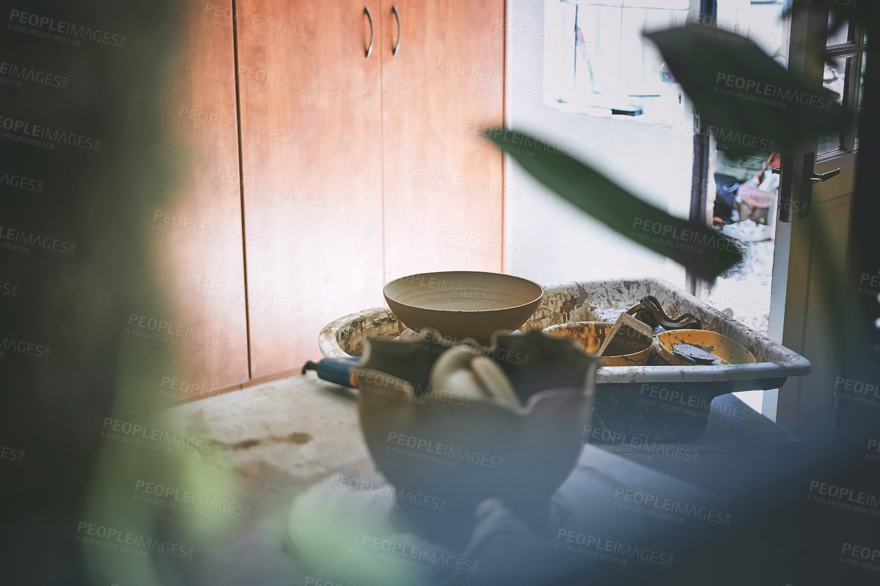 Buy stock photo Shot of a bowl made out of clay on a pottery wheel in a ceramic studio