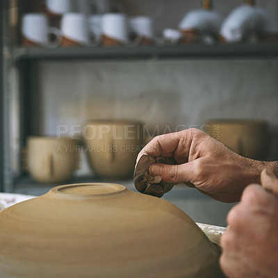 Buy stock photo Shot of an unrecognisable man working with clay in a pottery studio