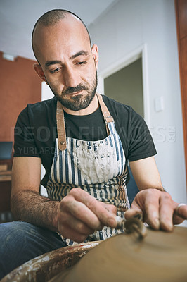 Buy stock photo Shot of a young man working with clay in a pottery studio