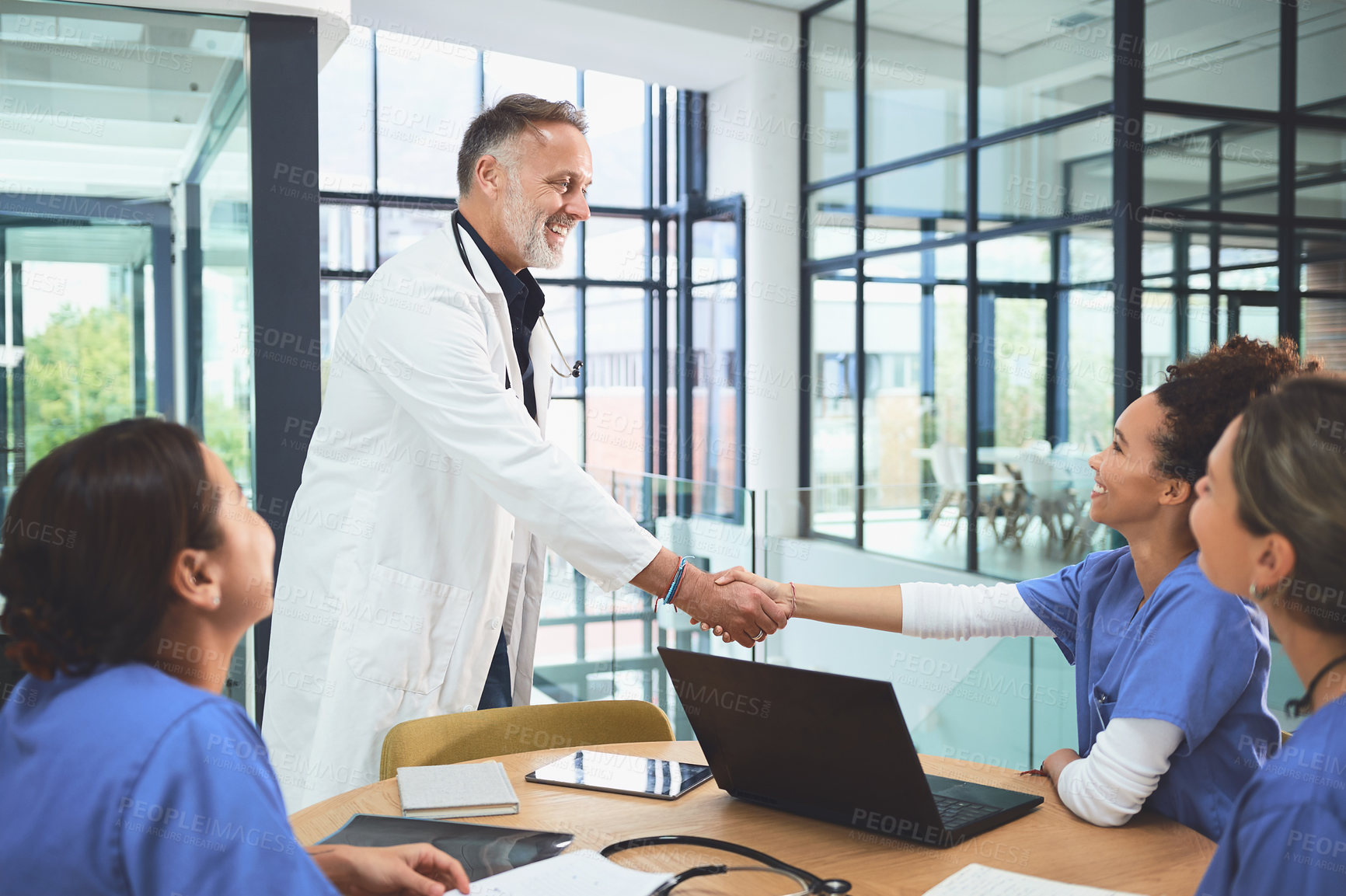 Buy stock photo Medical, handshake or people in hospital with laptop, greeting or cooperation in treatment research. Collaboration, meeting or doctors with tech, agreement or introduction in healthcare partnership.