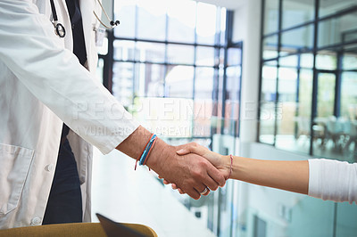 Buy stock photo Closeup shot of doctors shaking hands during a meeting in a hospital