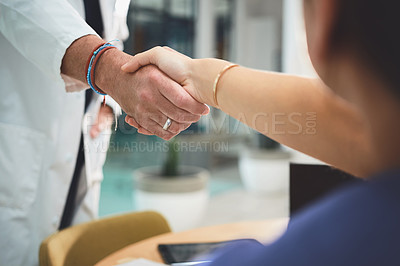 Buy stock photo Closeup shot of doctors shaking hands during a meeting in a hospital