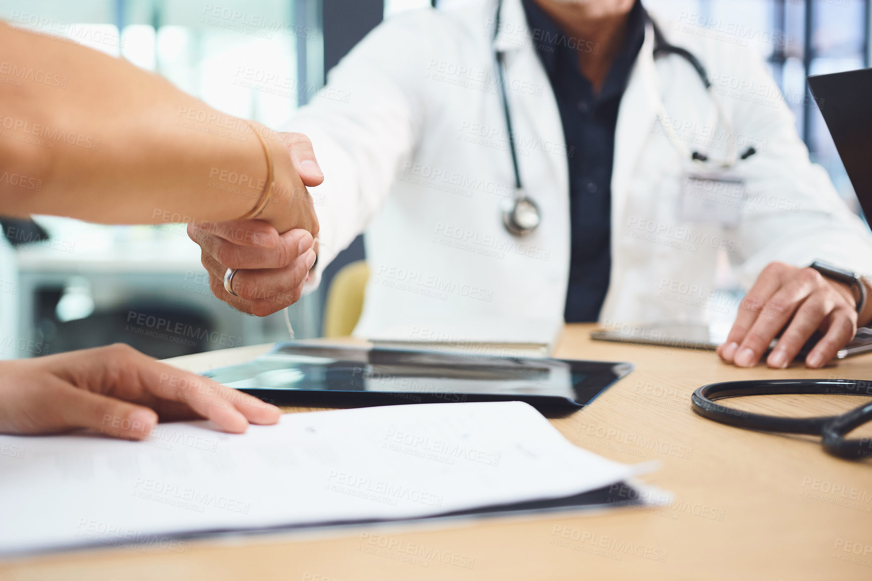 Buy stock photo Closeup shot of doctors shaking hands during a meeting in a hospital