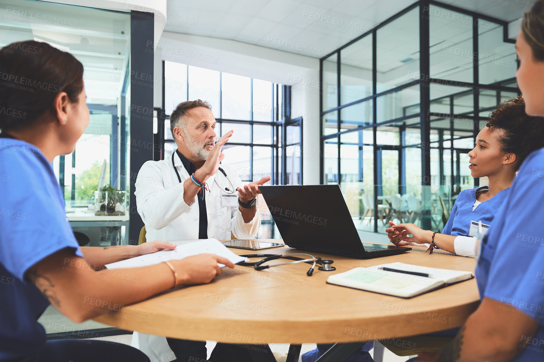 Buy stock photo Shot of a team of doctors having a meeting in a hospital