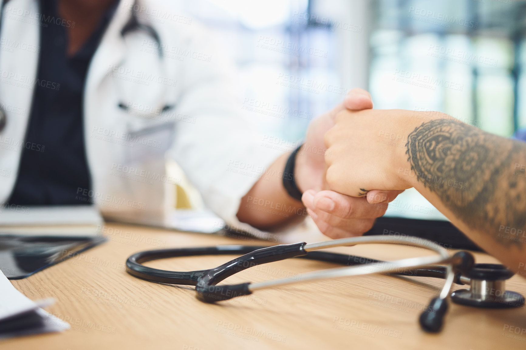 Buy stock photo Closeup shot of doctors shaking hands during a meeting in a hospital