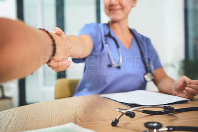 Buy stock photo Closeup shot of doctors shaking hands during a meeting in a hospital
