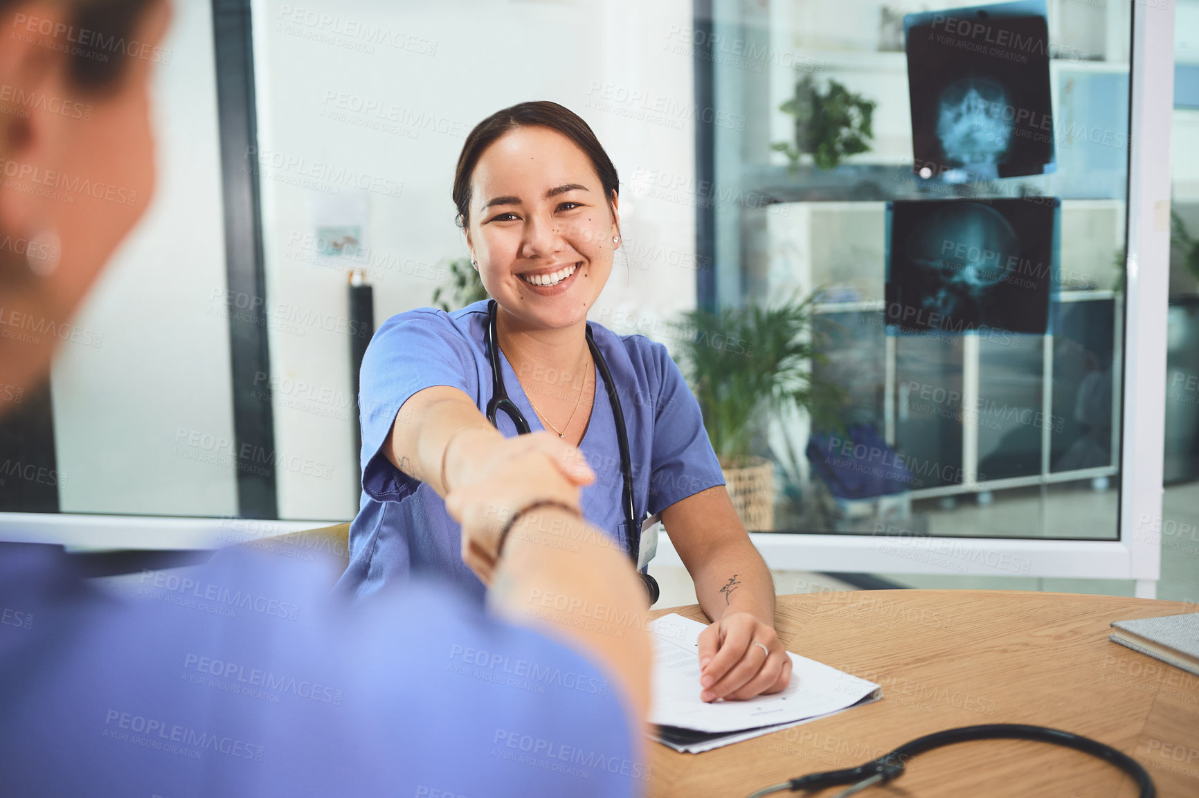 Buy stock photo Shot of doctors shaking hands during a meeting in a hospital