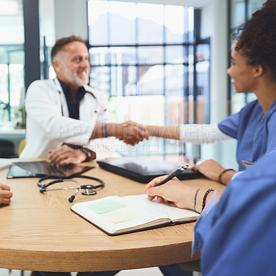 Buy stock photo Shot of doctors shaking hands during a meeting in a hospital