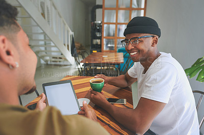 Buy stock photo Cropped shot of a handsome young man sitting with a friend in a coffeeshop during the day