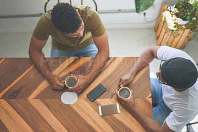 Buy stock photo High angle shot of two unrecognizable friends sitting together and bonding over coffee in a coffeeshop