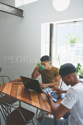 Buy stock photo Cropped shot of two handsome friends sitting together and using technology in a coffeeshop