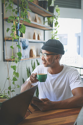 Buy stock photo Cropped shot of a handsome young man sitting alone and enjoying a coffee in a cafe