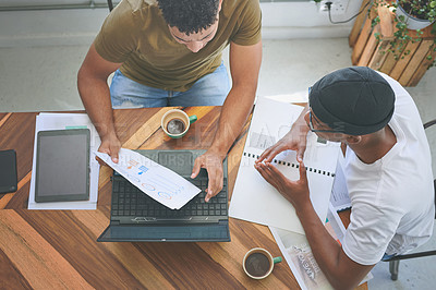 Buy stock photo High angle shot of two friends sitting together and using technology during a discussion in a coffeeshop