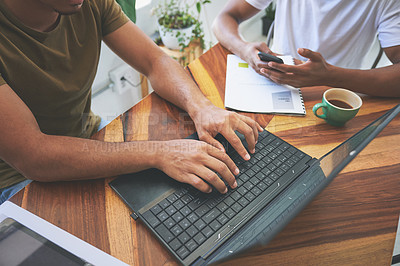 Buy stock photo Cropped shot of two unrecognizable friends sitting together and using technology in a coffeeshop