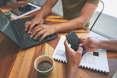 Buy stock photo Cropped shot of two unrecognizable friends sitting together and using technology in a coffeeshop