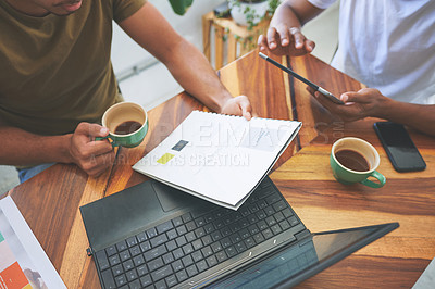 Buy stock photo Cropped shot of two unrecognizable friends sitting together and going through paperwork in a coffeeshop