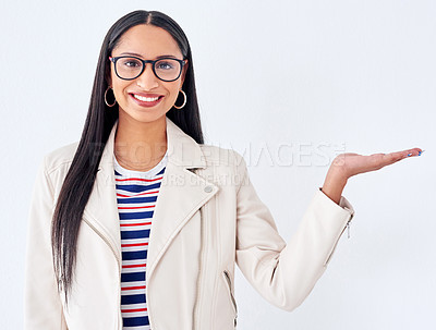 Buy stock photo Studio portrait of a young woman gesturing to copyspace against a white background