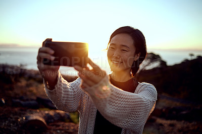 Buy stock photo Hiking, selfie and Asian woman on mountain with sunset sky, smile and relax in nature on holiday adventure. Digital photography, outdoor trekking and girl with evening view, ocean and vacation memory