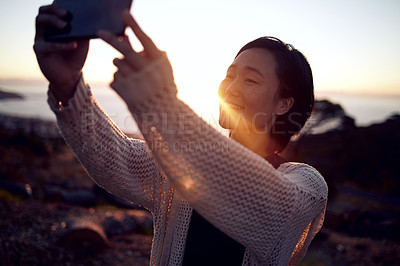Buy stock photo Shot of a woman taking pictures on her cellphone while spending time outdoors