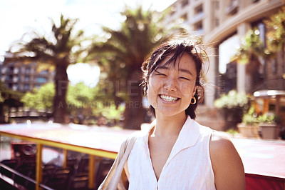 Buy stock photo Cropped portrait of an attractive young woman exploring the city alone during the day