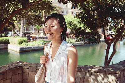 Buy stock photo Asian woman, smile and park travel on holiday in Indonesia or exploring at lake for weekend, trip or relax. Female person, summer and nature garden or walking commute in forest, trees or adventure