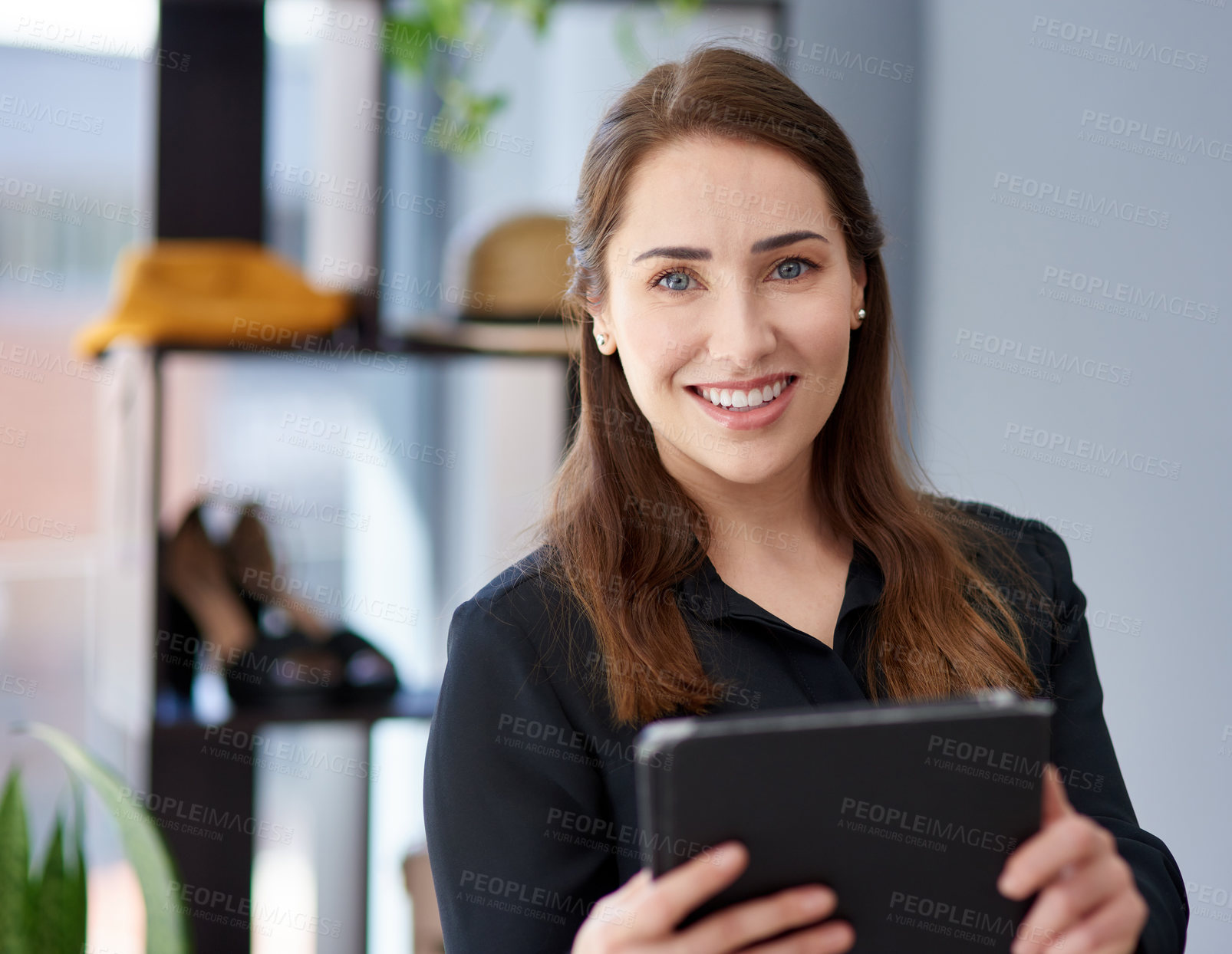 Buy stock photo Portrait of a young business owner using a digital tablet in her clothing store