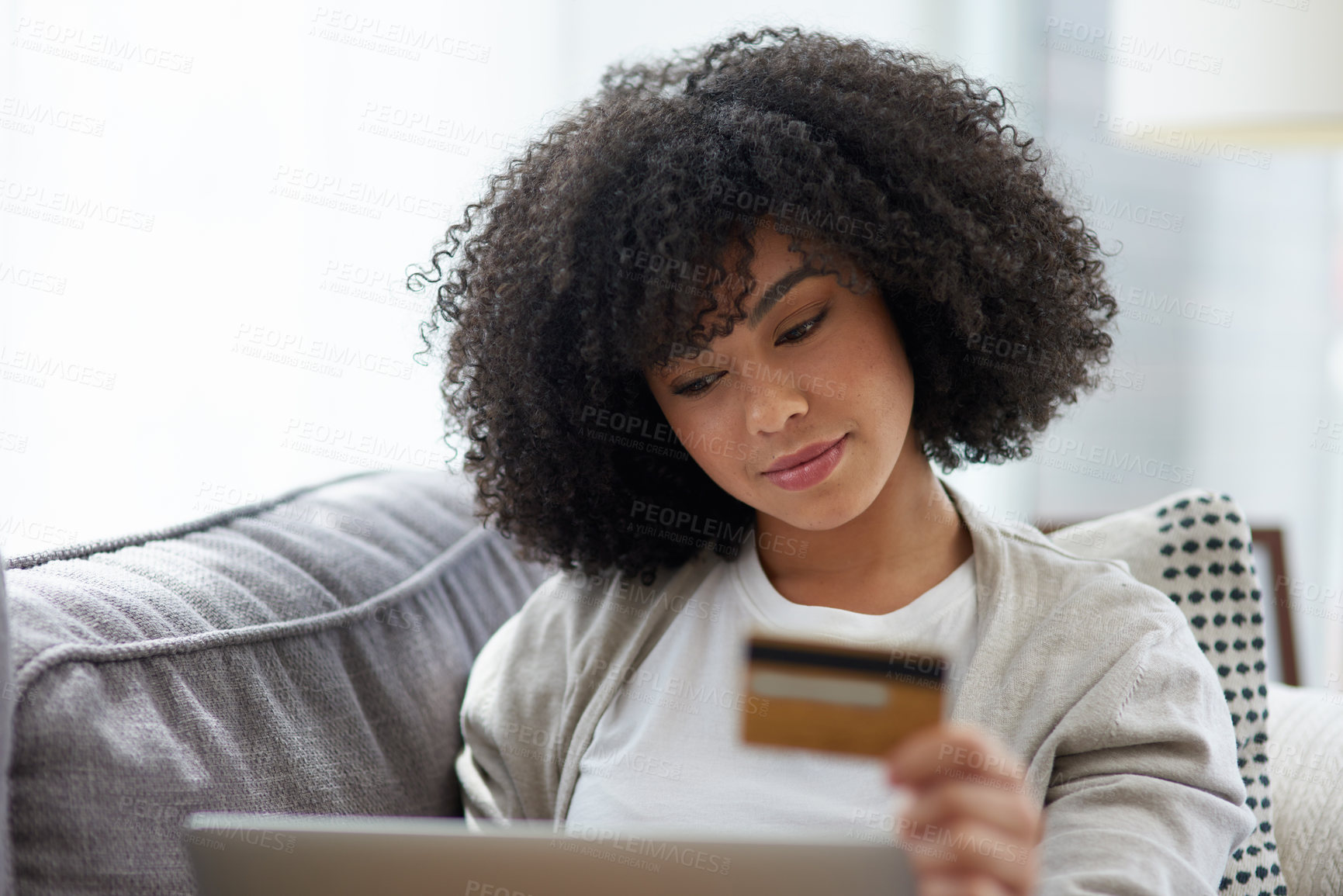 Buy stock photo Shot of a young woman using a laptop and credit card at home