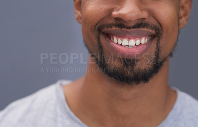 Buy stock photo Cropped shot of an unrecognizable young man standing alone and smiling